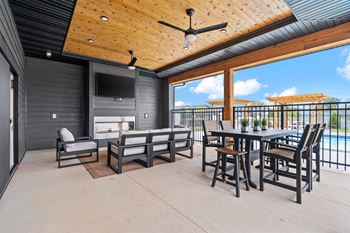 the patio has a large table with chairs and a fireplace